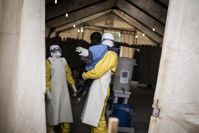 Luis Encinas est un des spécialistes d'Ebola chez MSF. Il tient dans ses bras un garçon de sept ans atteint par la maladie. Centre de traitement d'Ebola de Butembo. République démocratique du Congo. 2018.