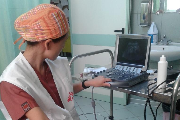 Une gynécologue obstétricienne de MSF fait une échographie à une patiente libyenne.