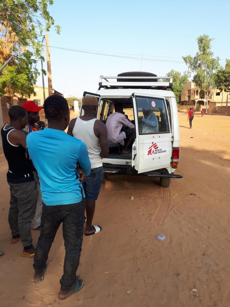 L'équipe médicale de MSF organise des cliniques mobiles régulières à Wadata. Ici, des migrants attendent leur consultation près d’un des sites de l’OIM, à Niamey. Décembre 2018
 © Anna Fliflet/MSF