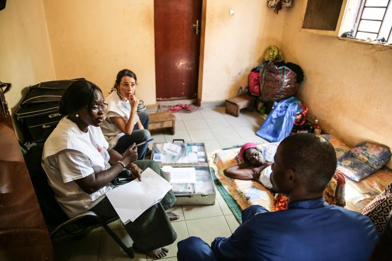 Le Dr. Djénabou Diallo et l'infirmière Nathalie Kornfein en discussion avec une patiente et sa famille à leur domicile. Bamby a 77 ans et elle est atteinte d'un cancer du sein. Les échanges sont importants dans les soins de supports et palliatifs, notamment pour répondre aux nombreuses questions concernant l'état du patient. Mali. 2019.&nbsp;
 © MSF/Mohammad Ghannam