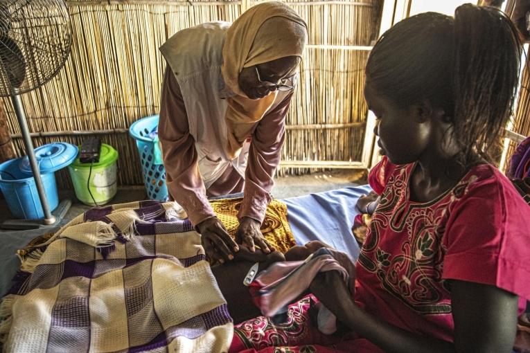 Zakina Adam Ali, superviseure nutritionnelle, vérifie l'état du fils de Julia, Emmanuel, 3 ans,&nbsp;qui est traité pour malnutrition dans le centre d'alimentation thérapeutique&nbsp;du nouvel hôpital MSF à Al Kashafa, dans l'État du Nil blanc au Soudan.
 © MSF/Igor Barbero
