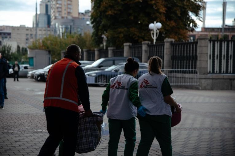 Des membres des équipes MSF portent les effets personnels d'un patient évacué de Kharkiv. Ukraine. 2022.
 © MSF/Hussein Amri