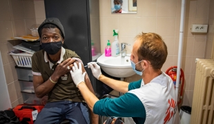 Marc Begue, infirmier MSF, vaccine Sidibé dans un centre de la Fondation de l'Armée du Salut à Paris.