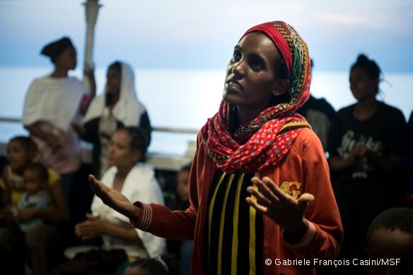 Une femme érythréenne chante une prière avec d'autres femmes et enfants après avoir été secourue le 2 septembre 2015 en mer Méditerranée par le MY Phoenix, bateau de recherche et de sauvetage de MSF.
