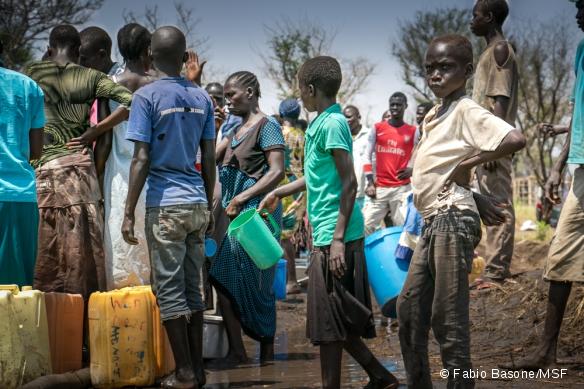 Dans le camp de Palorinya, des réfugiés viennent chercher de l'eau, alors que le camion-citerne est embourbé. La saison des pluies risque de rendre l'approvisionnement en eau potable difficile.