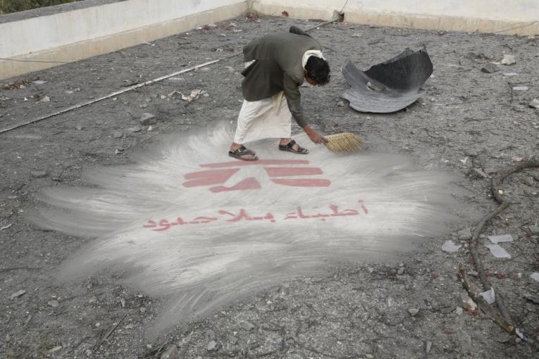 Un homme balaye des débris du bombardement du 26 octobre sur l’hôpital de Haydan révélant le logo MSF peint sur le toit de l'hôpital.