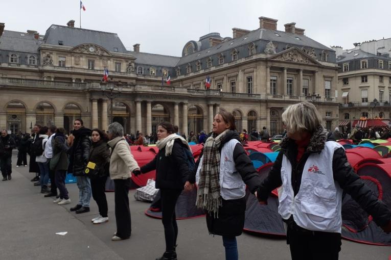 Des membres d'associations forment une chaîne de protection humaine devant le Conseil d'État à Paris lors d'une action pour alerter sur la situation des jeunes étrangers, le 2 décembre 2022