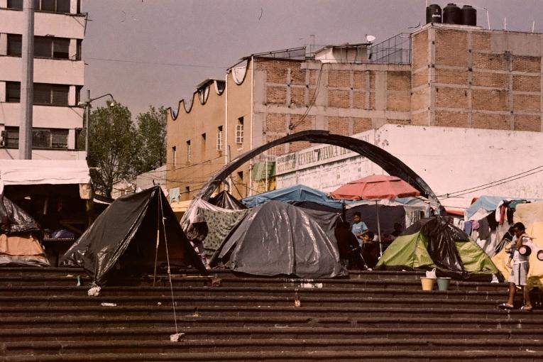 Sur la Plaza de la Soledad, au cœur de Mexico, des migrants venus de différentes régions du monde vivent dans des abris de fortune. Mars 2025, Mexique.