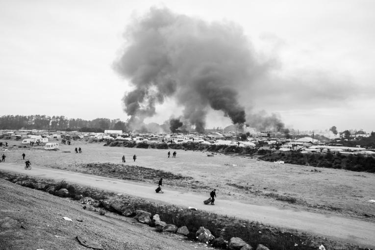 Vue d'ensemble sur un campement de fortune à la frontière franco-britannique. La fumée la violence dans ces camps.
