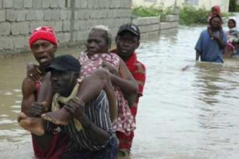 Des Haïtiens traversent une rivière après qu'une série de tempêtes se soit abbatue sur l'île.