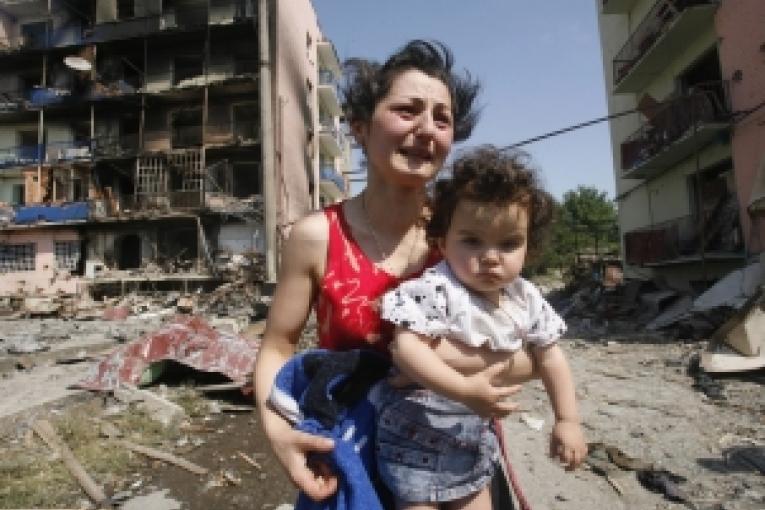 Géorgienne et son enfant fuyant leur maison détruiteà Gori le 10/08/2008