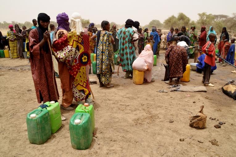 Attente devant un point d'eau dans le camp de Férrerio au Burkina Faso.