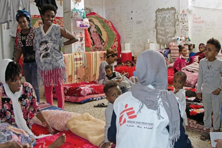 Un membre des équipes MSF échange avec un groupe de femmes et d’enfants détenus dans le centre de Khoms. 50 femmes et enfants se trouvaient dans cette cellule, les détenus hommes étaient dans une autre cellule.  Libye. 2018.