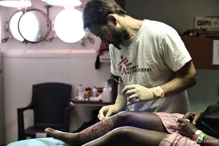 Les équipes de Médecins Sans Frontières présentes à bord de l'Aquarius offrent des soins de santé aux rescapés secours lors d'opérations de recherche et de sauvetage. François-Xavier Daoudal traite ici une brûlure. 2018. Méditerranée.