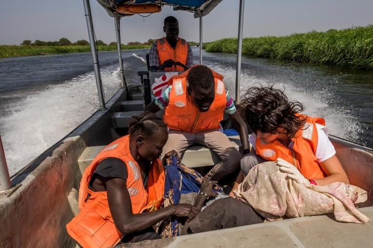 Camille, une sage-femme de l'hôpital MSF de Old Fangak, contrôle le travail de Martha, une patiente de 36 ans, en posant sa main sur son ventre, tandis que le bateau appelé en urgence pour la récupérer fonce à pleine vitesse vers Old Fangak. Perclus de douleur et de contractions, la jeune femme est couchée au fond de l’embarcation, appuyée sur un banc.