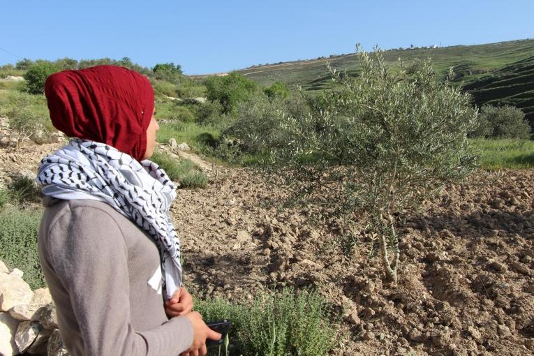 Estabarak, 17 ans, habite le village de Madama en Cisjordanie. Elle se tient devant sa maison et regarde en direction de la colonie devant laquelle elle s'est fait tirer dessus. Elle est suivie par l'équipe de psychologues de Médecins Sans Frontières. 2018.