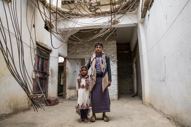 Les enfants de la famille Ghani posent devant l'entrée de leur maison, bombardée pendant la guerre de Saada, entre 2004 et 2010. Haydan. Yémen. mars 2018.