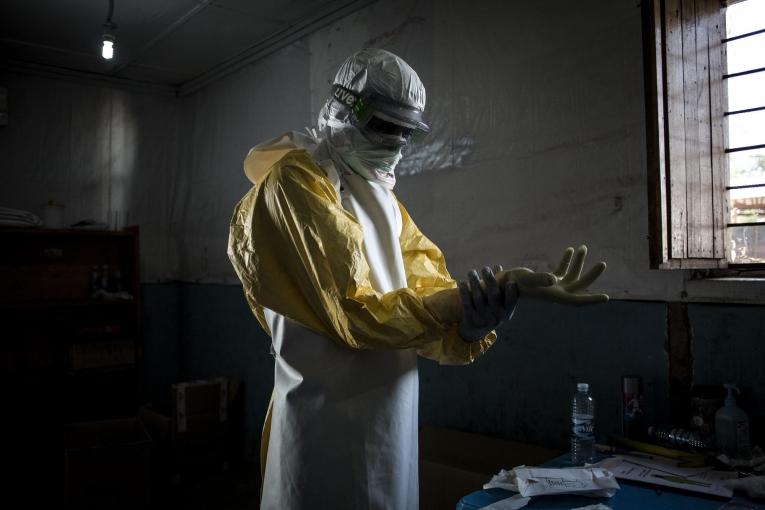 Un travailleur de santé MSF revêt son équipement de protection personnel avant d'entrer dans la zone à risque du centre d'isolement Ebola de Bunia. Il va procéder à une évaluation de l'état des patients. Novembre 2018. République démocratique du Congo.