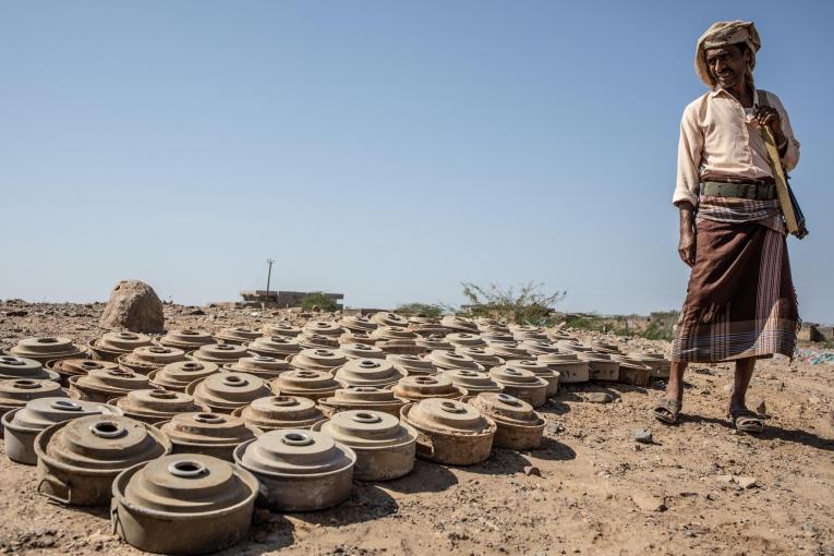 Un homme armé devant des mines désamorcées. Mawza. Décembre 2018. Yémen.