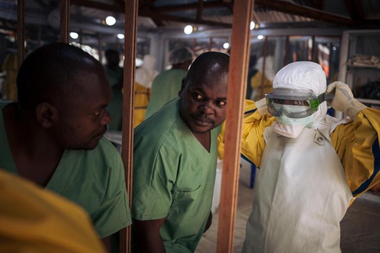 Un travailleur de santé revêt son masque avant d'entrer dans la zone à risque d'un centre de traitement Ebola. Novembre 2018. République démocratique du Congo. 
