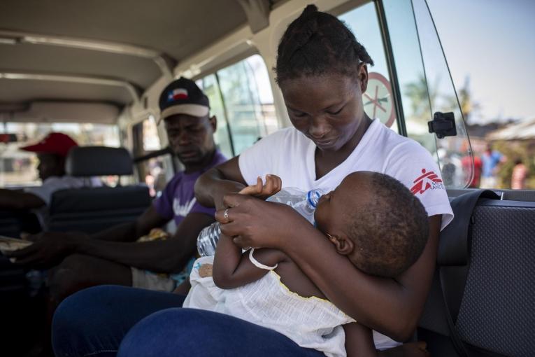 Aida Joao, travailleuse communautaire MSF, évacue un enfant suspecté d'être atteint de pneumonie d'un bidonville de Beira, où MS effectue des cliniques mobiles depuis le cyclone Idai. Mozambique, 26 mars 2019.
