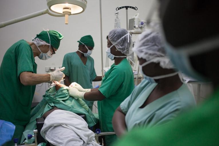 Un chirurgien de l'hôpital MSF SICA à Bangui tente d'extraire une balle profondément logée dans l'épaule d'un patient. Avril 2018. République centrafricaine. 