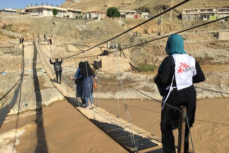 Une équipe MSF traverse un pont pour se rendre dans le village situé de l'autre côté de la rivière Kashkan. 2019. Iran.