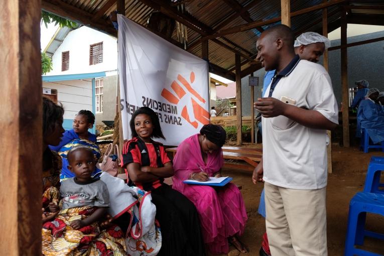 Joseph MbokaniI Kambale, l’un des agents de sensibilisation déployés par le dispositif national de réponse à Ebola, répond aux questions des participants. Les craintes et les rumeurs découragent de nombreuses personnes de se faire vacciner. République démocratique du Congo. 2019.