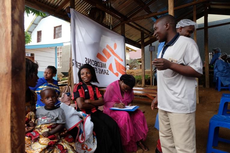 Joseph MbokaniI Kambale, l’un des agents de sensibilisation déployés par le dispositif national de réponse à Ebola, répond aux questions des participants. Les craintes et les rumeurs découragent de nombreuses personnes de se faire vacciner. République démocratique du Congo. 2019. 