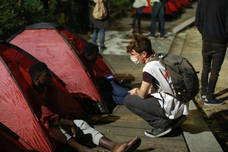 Un travailleur social MSF discute avec un mineur isolé étranger lors de l'installation du camp à Paris, près de la place de la République. 2020. 