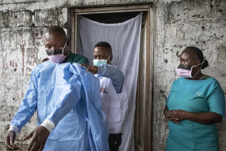 L’épidémiologiste Gaston forme et aide le personnel local du centre de santé Le Temps d’un Soir de Mbandaka à enfiler les équipements de protection donnés par MSF pour améliorer la protection et le contrôle des infections dans ce centre de santé qui a connu 8 cas confirmés Ebola au début de l’épidémie. Mbandaka, Equateur, RDC, 27 octobre 2020.