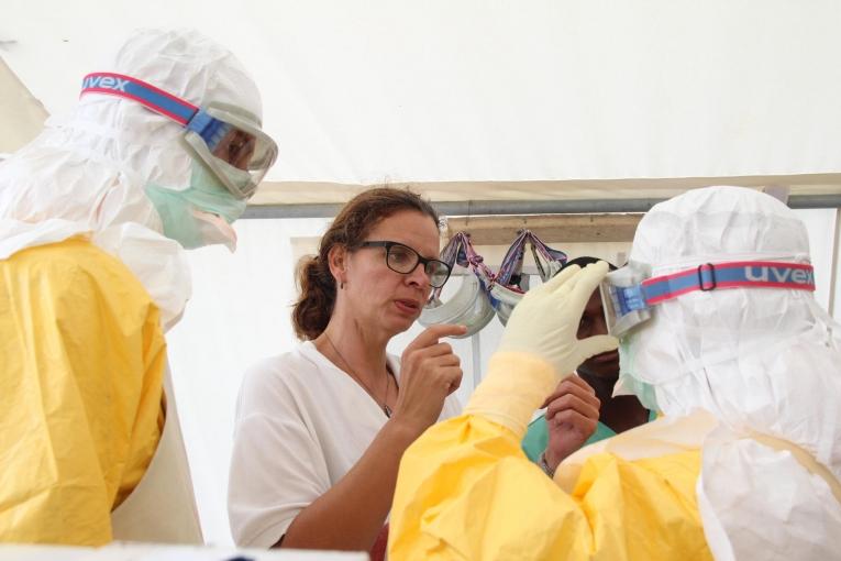 Anja Wolz aide ses collègues à enfiler un kit de protection Ebola lors de la grande épidémie qui a frappé l'Afrique de l’Ouest en 2014-2016.
