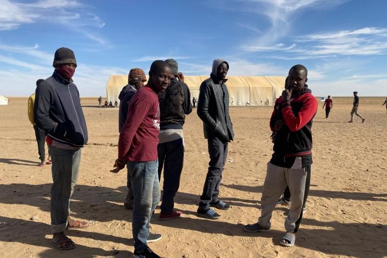 Un groupe de jeunes hommes attendant pour recevoir de la nourriture à Assamaka, après avoir été expulsés d'Algérie. Niger. Mars 2021.