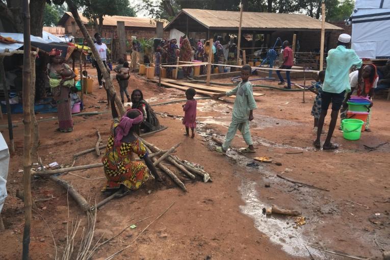 Des personnes déplacées, suite à l'incendie du camp d'Élevage, remplissent des jerricans à un point d'eau dans l'enceinte de la mosquée de Bamabri. République centrafricaine. 2021.