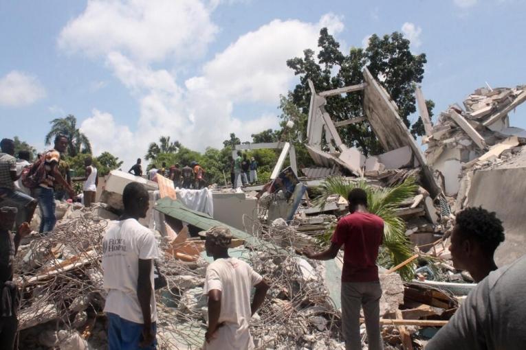 Des gens fouillent les décombres de l'hôtel Manguier après le tremblement de terre du 14 août 2021 aux Cayes, dans le sud-ouest d'Haïti.