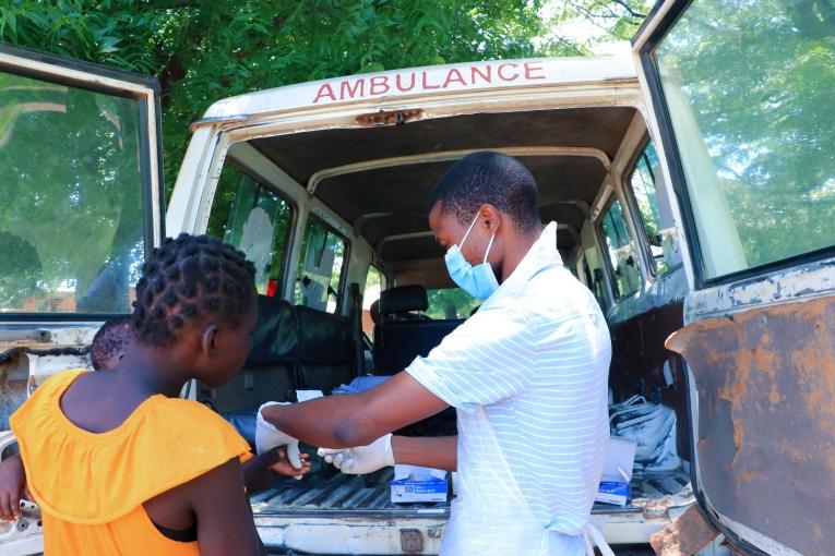 Un employé du ministère de la Santé en discussion avec un patient dans la province de Nsanje où MSF offre un soutien logistique aux personnes déplacées par la tempête Ana. Malawi. 2022.