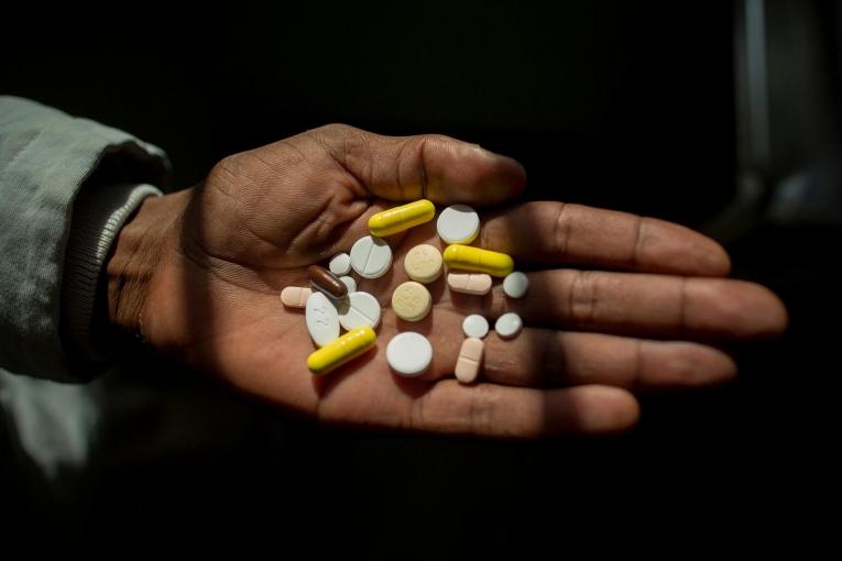 Un homme tient dans sa main ses médicaments contre la tuberculose. Afrique du Sud. 2016.