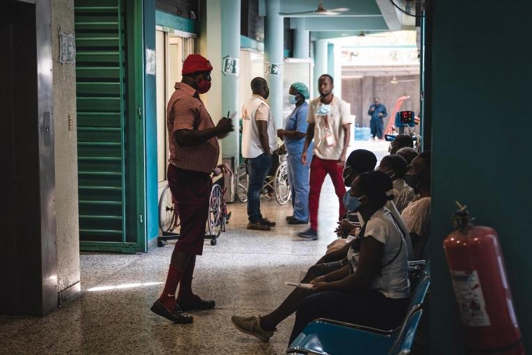 Un membre du personnel soignant parle aux patients dans la zone de triage du centre d'urgence MSF de Turgeau. 