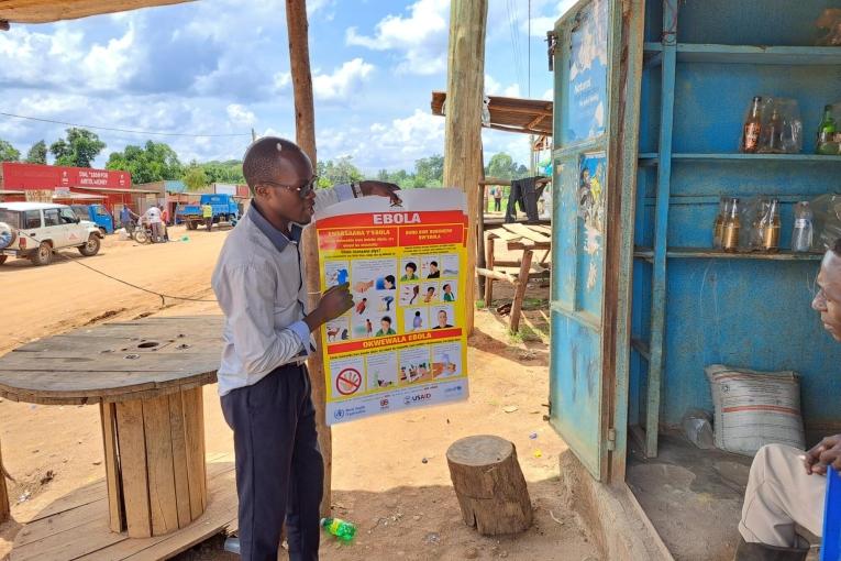 Un promoteur de santé MSF en discussion avec le propriétaire d'un commerce à Madudu, à proximité de l'épicentre de l'épidémie d'Ebola. Ouganda. 2022.