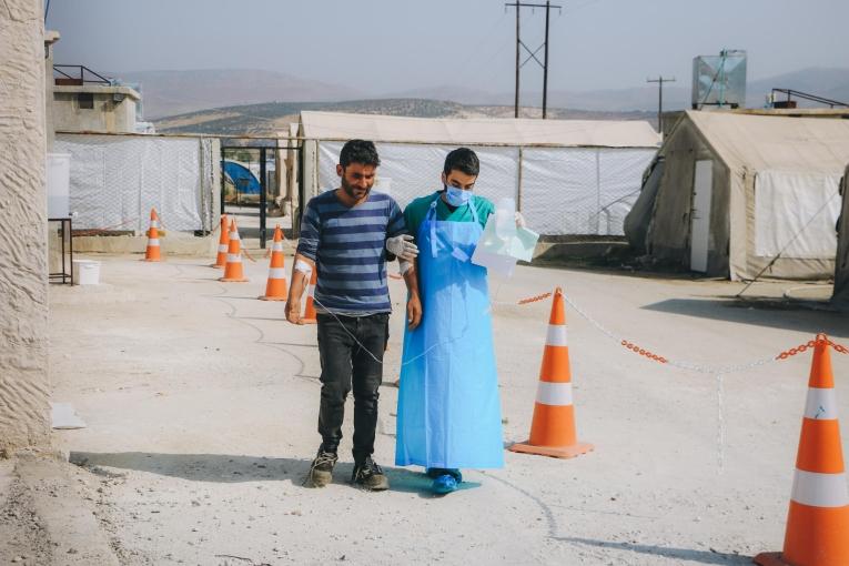 Un travailleur de santé accompagne un patient dans une unité de traitement du choléra MSF installée dans la région d'Idlib. Syrie. 2022.