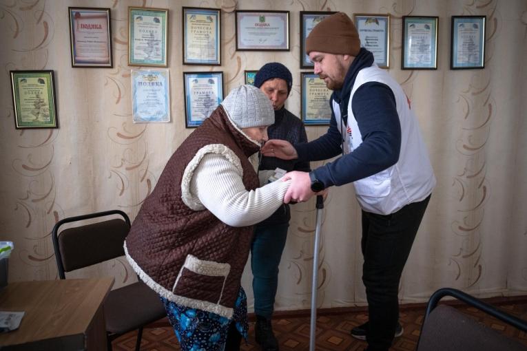 Un médecin MSF aide une patiente atteinte de diabète à se lever. Ukraine. 2022.