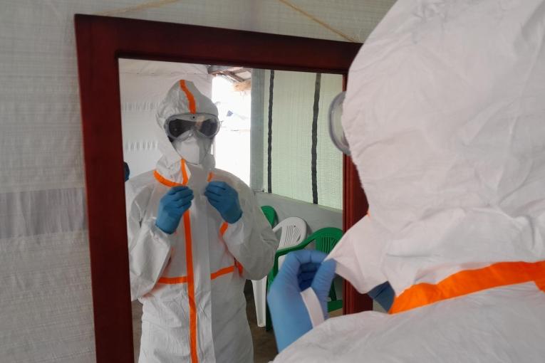 Vue d'un membre du personnel MSF en tenue de protection individuelle dans le centre de traitement de Mubende. Ouganda. 2022.