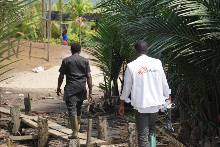 L'équipe MSF composée d'un coordinateur d'urgence, d'un superviseur DMC, d'un responsable de la communication et de volontaires de santé communautaire, marche pour atteindre le village d'Enyenge où ils mènent le deuxième jour de la campagne de vaccination contre le choléra.