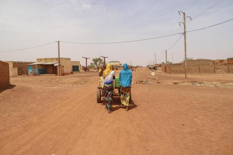 Centre-ville de Djibo - deux femmes poussant une charrette d'eau.
