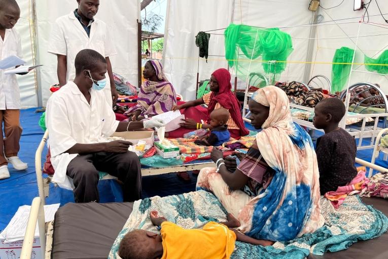 Un membre des équipes MSF avec une mère et son enfant dans l'hôpital d'Adré au Tchad. 2023.