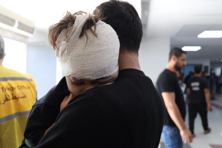 Un enfant blessé par un bombardement aérien dans les bras de son père, après avoir reçu des soins à l'hôpital Al-Shifa. 