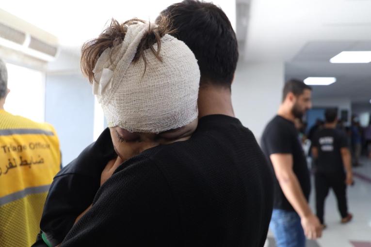 Un enfant blessé par un bombardement aérien dans les bras de son père, après avoir reçu des soins à l'hôpital Al-Shifa.