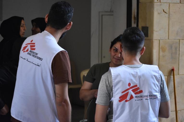 Des membres des équipes MSF en discussion avec une personne déplacée installée dans le refuge d'Azarieh à Beyrouth, lors d'une clinique mobile. Octobre 2024. Liban.
