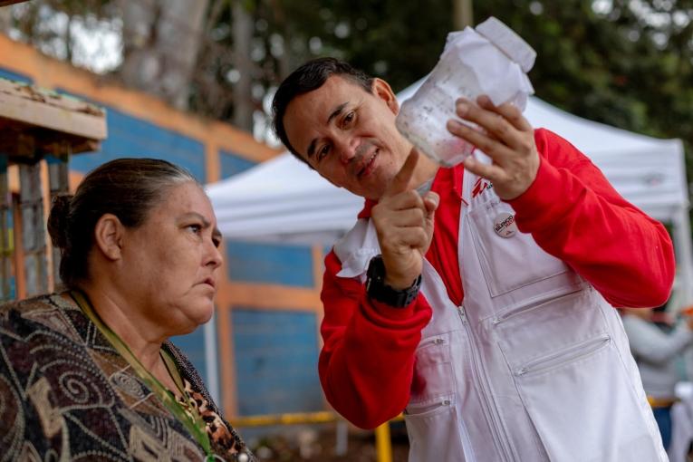Une habitante d'El Manchen au Honduras, en discussion avec un membre des équipes MSF lors d'une opération de relâchement de moustique.