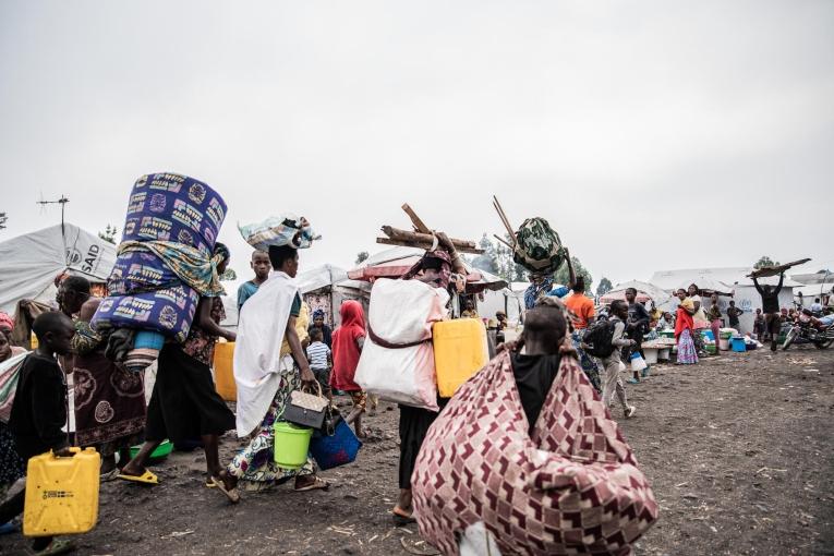 Des familles quittent les camps de Lushagala et Bulengo, portant leurs colis sur le dos et sur la tête. Certains déplacés prennent la route à pied.